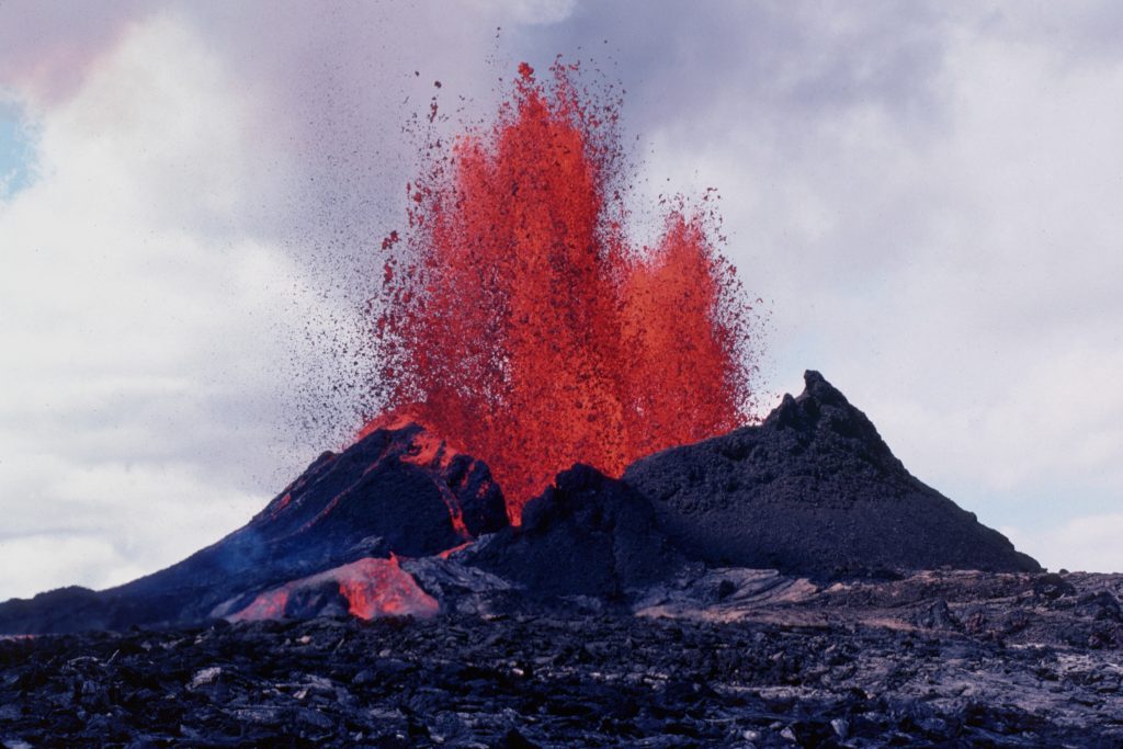 red lava bursts out of a volcanic crater